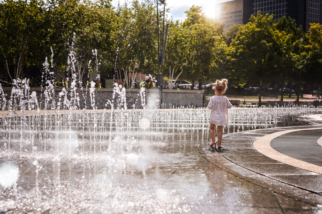 Little girl playing in fountain