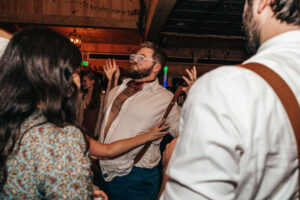 groom dancing and holding suspenders