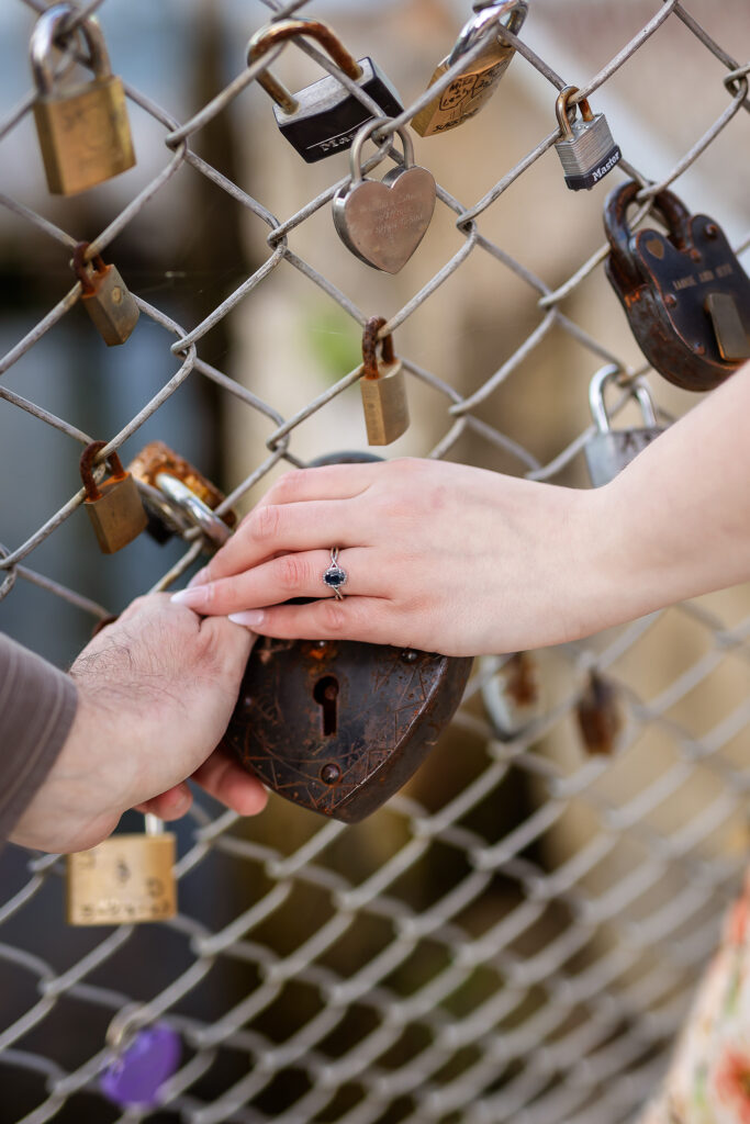 Couple holding heart shaped lock at the Love Wall in Portsmouth NH Engagement Photos by Lisa Smith Photography 