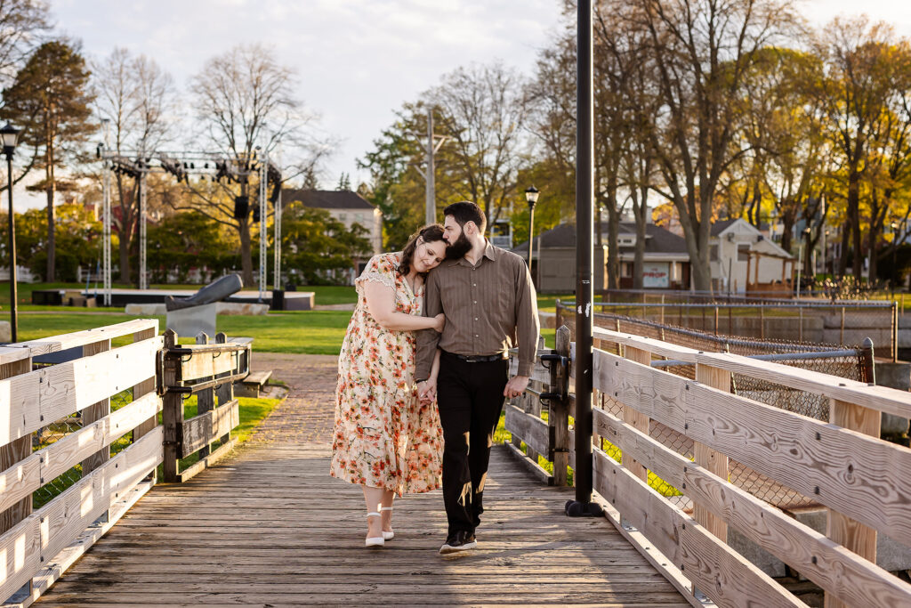 Couple walking and snuggling on pier at Prescott Park in Portsmouth NH Engagement Photos by Lisa Smith Photography 