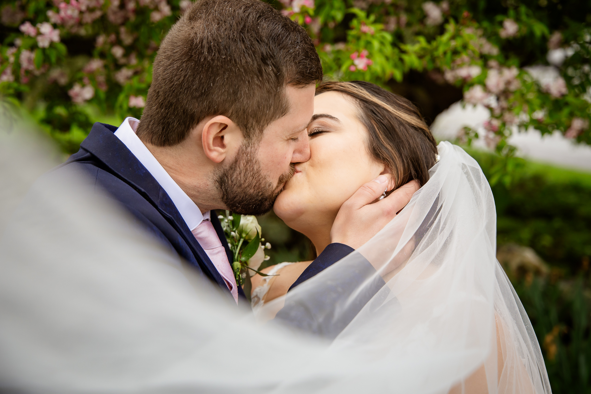 What to Ask a Wedding Photographer - bride and grooms kissing with sweeping vail through frame by NH wedding photographer Lisa Smith Photography