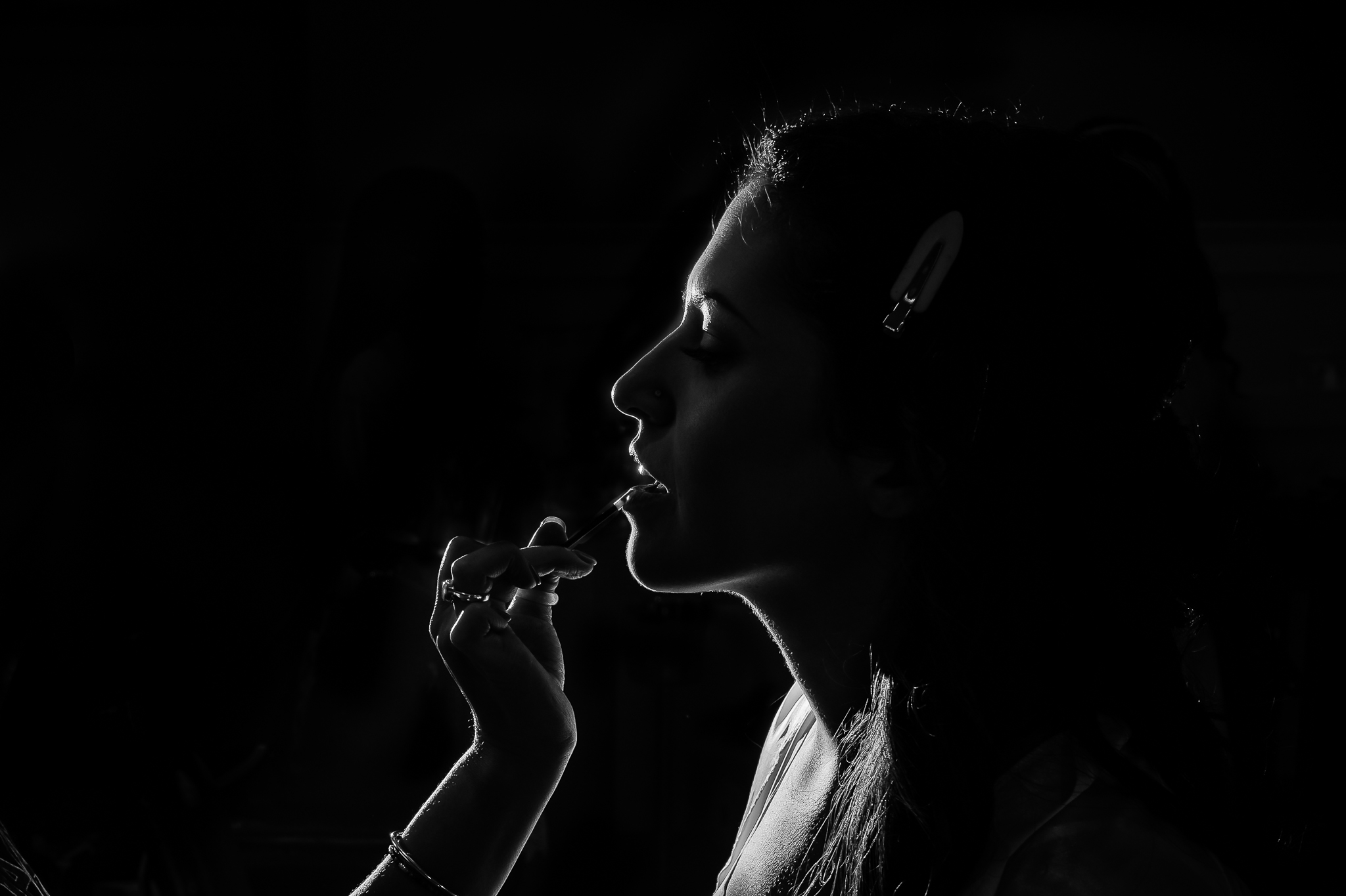 MAU putting lipstick on bride in low light black and white photo by NH wedding photographer Lisa Smith Photography