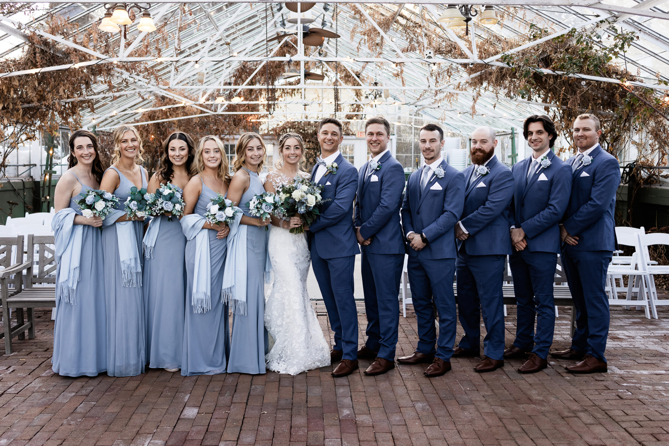 What to Ask a Wedding Photographer - bridal party portrait in greenhouse during winter wedding at The Barn on The Pemi by NH wedding photographer Lisa Smith Photography