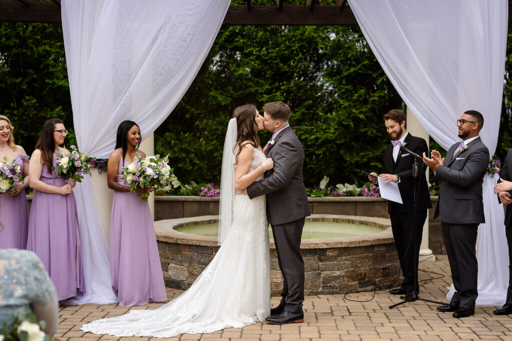 Bride and grooms first kiss as husband and wife during ceremony at Birchwood Vineyard in Derry NH by Lisa Smith Photography