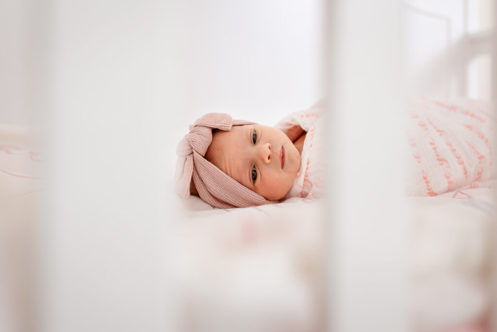 Baby girl in crib at in home newborn photo session by NH Newborn Photographer Lisa Smith Photography