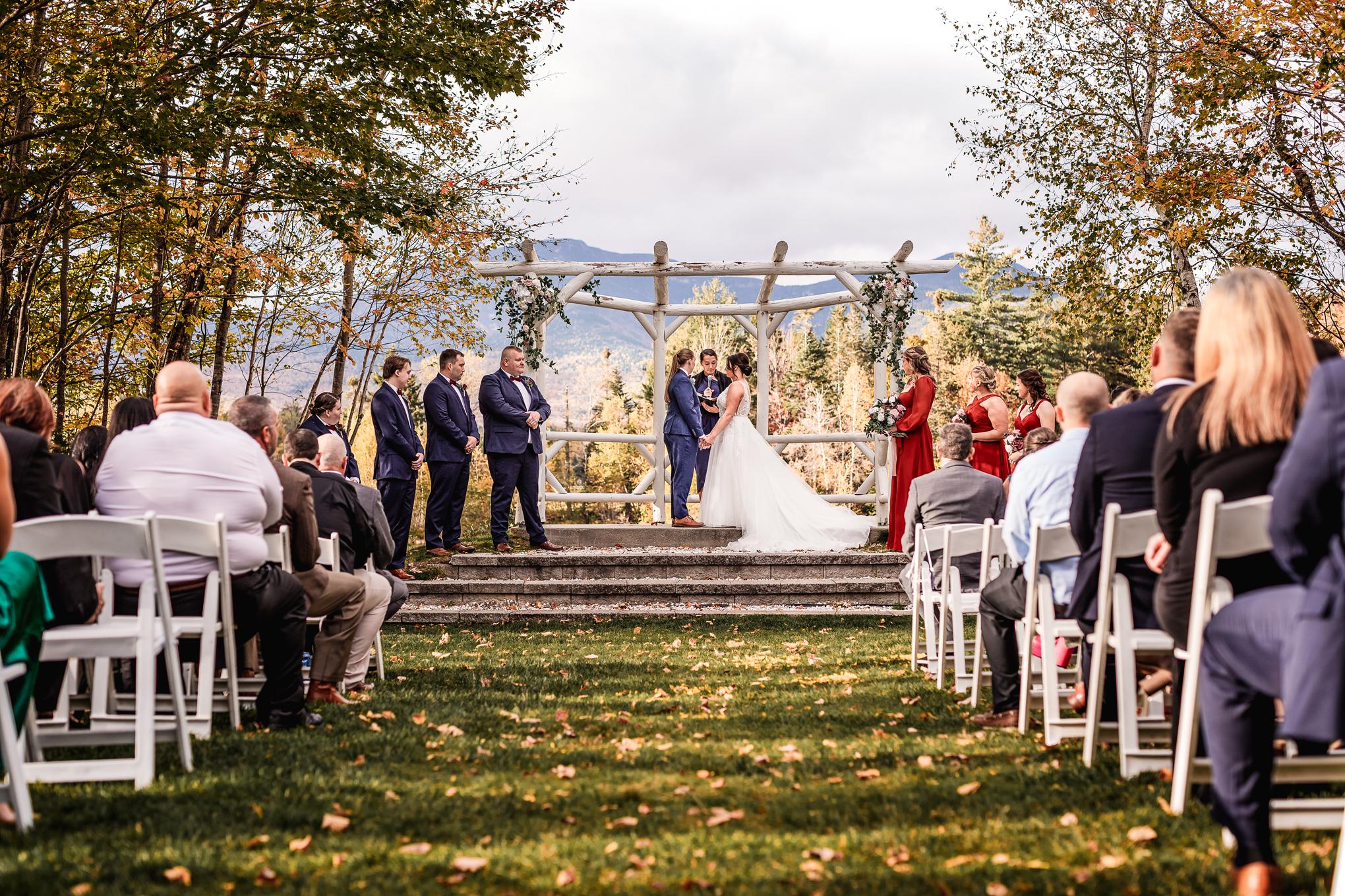 Brides holding hand in front of arbor at Waterville Valley wedding ceremony by nh wedding photographer Lisa Smith Photography