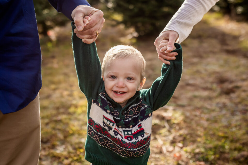 Little boy holding parents hands by NH family photographer Lisa Smith Photography