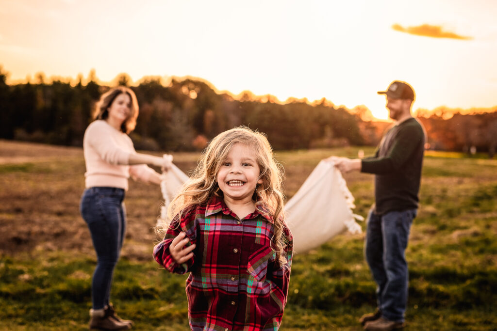 Toddler running under blanket at Wagon Hill Family photoshoot by NH family photographer Lisa Smith Photography