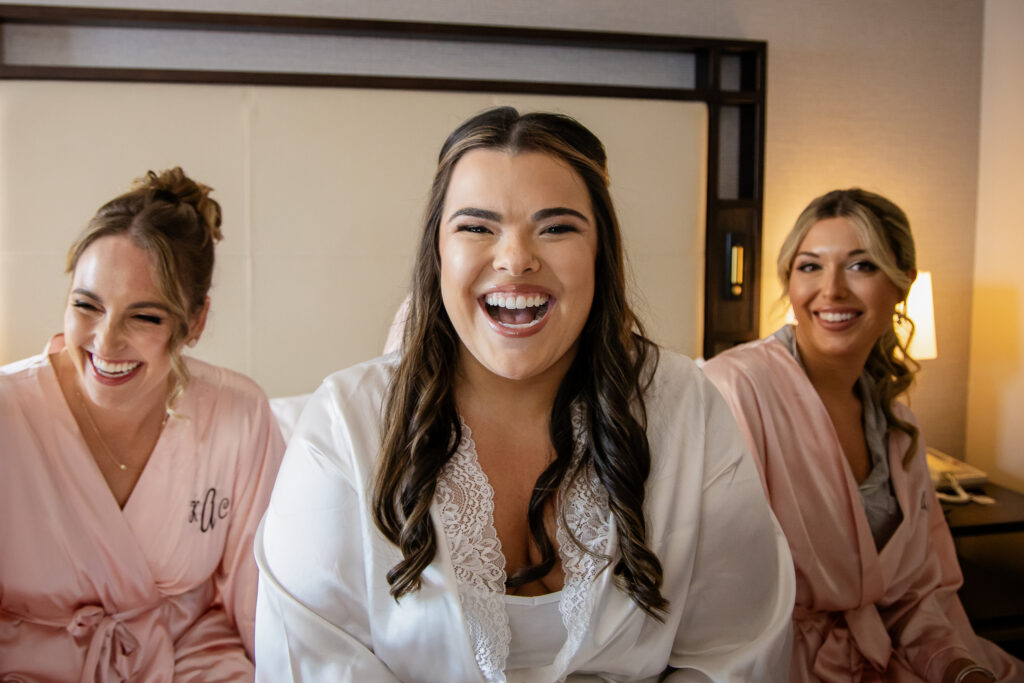 Bride laughing after having her wedding makeup done while getting ready by NH Wedding Photographer Lisa Smith Photography