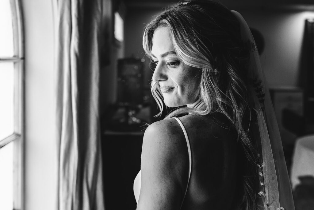 Stunning black and white portrait of bride by window