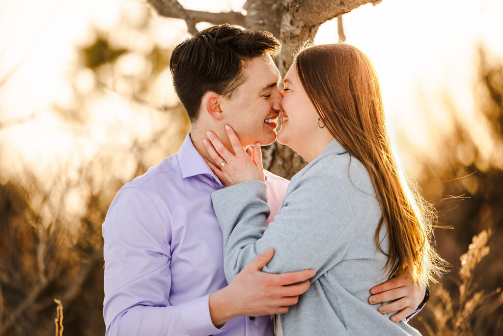 Close-up of engaged couple smiling and embracing during golden hour in New Hampshire engagement photos